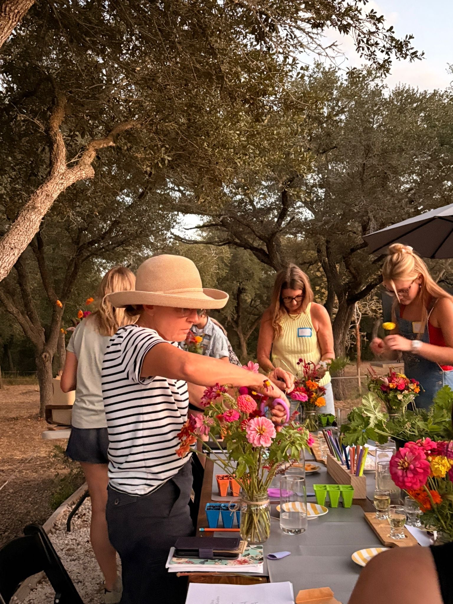 Participants creating floral arrangements during an on farm workshop at a Texas flower farm