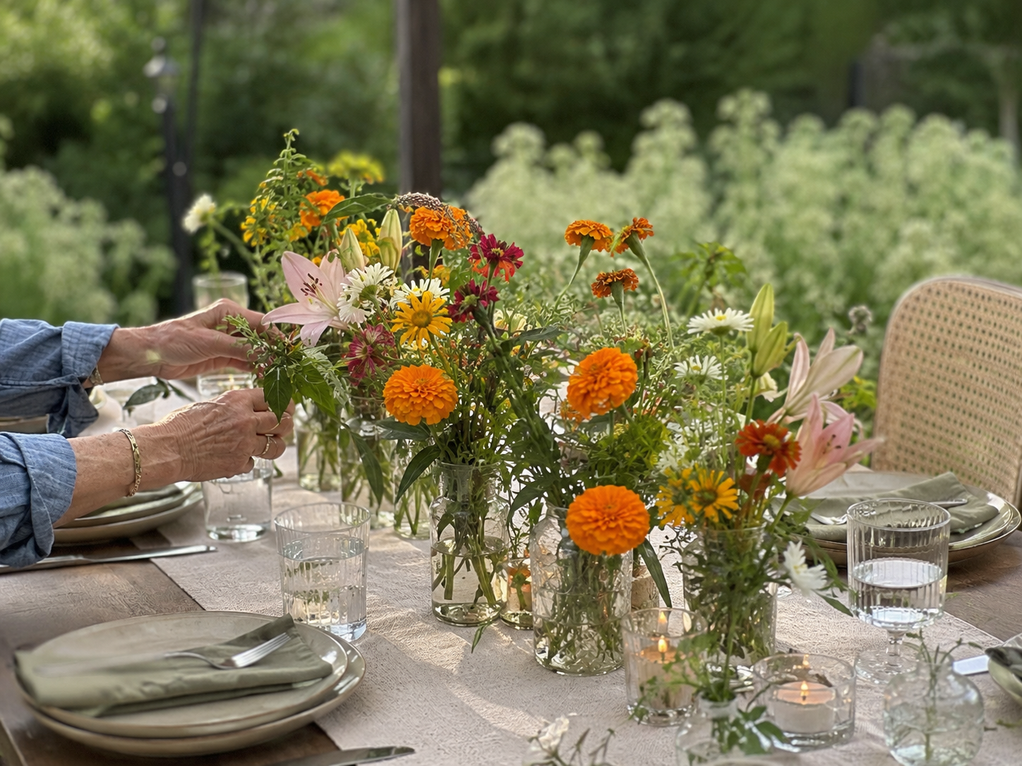 Seasonal farm-grown flowers arranged for a summer dinner table with natural movement and texture.