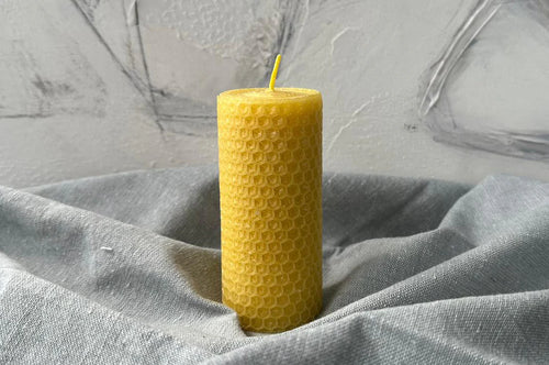 Close-up of a pure beeswax pillar candle showing natural texture